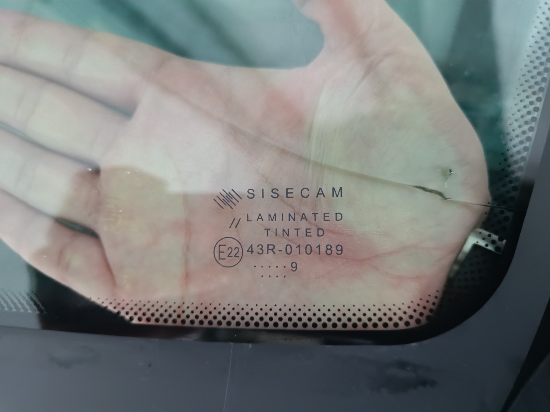 В общем, машина стояла на улице весь ноябрь. Приехал с командировки и утром завёл, а сам пошел домой пить чай пока она грелась. Через пол часа выхожу и вижу, что по всей длине лобовой появилась трещина от небольшого скола — поймал камушек летом, когда ехал на море.

Трещина на всю длину. Стекло SISECAM
Вроде особо и не мешается, но напрягало, что находится на уровне глаз. Так покатался где-то месяц и решил позвонить нескольким фирмам, так сказать узнать цены рынка. Первой фирмой оказалась AG Experts. Цену за стандартное стекло Бор с небольшим затемнением и зелёным оттенком озвучили 7800 рублей. Установка бесплатная. После этого даже звонить не стал другим фирмам, а сразу записался на удобную дату — цена меня устроила. Во время разговора уточнил ещё раз нужную модель стекла с евро-кодом 4592AGS и переспросил точно будет оригинальный Бор, а не какой-то кооператив… Ответили, что будет 100% Бор, который сейчас ставят на конвейер, надо только выбрать вариант его исполнения: с датчиками или без, и т.п. Попросили в день установки заранее заехать на мойку.

А вот и мойка. Прайс — космос для Уфы, одна фаза 600 рублей 🙂 и это только наружка…
После мойки заехал в соседний бокс, где уже весёлые ребята за несколько минут разобрали жабо и сняли старое лобовое.

Старое заводское стекло SISECAM
На фото видно тот самый скол, с которого всё пошло по швам…

Парни срезали лишний герметик и обезжирили поверхность
Видно, что на заводе особо не заморачиваются и наносят герметик так себе. Теперь понятно, почему у некоторых владельцев вода в салоне: на фото можно найти уязвимые места.

Новое стекло установлено. Теперь у нас Бор.
Пол часа и готово!

Стекло ветровое Бор 8450007323 E22 43R-000122 Lamisafe
После того как приклеили, я ещё часик погулял в ближайшем ТЦ пока схватится герметик, вернулся и успел пообщаться с мастерами. Прошло 2 часа и я не спеша поехал домой.

P.s. Парни сказали, что стекла AGS и Бор делают в одном заводе, чему я был удивлён.